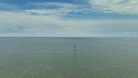 aerial view wind surfer in sea. drone flight over calm sea surface with glissing windsurfer. shot from above 4k slow motion