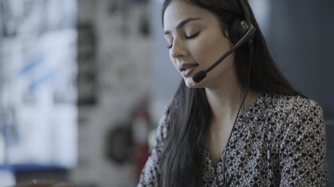 Close up of stressed businesswoman removing headset in call center / Pleasant Grove, Utah, United States