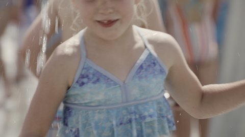 Close up of happy girl jumping in water park splash pad / Cedar Hills, Utah, United States