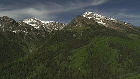 Aerial panning shot of trees in mountain range / American Fork Canyon, Utah, United States