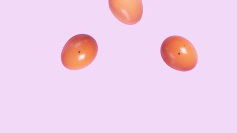 Stop motion brown chicken easter eggs falling down on purple background