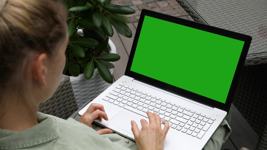woman using laptop computer on a outdoor terrace, blank green screen mockup copy space Royalty-Free Stock Footage #1058024707