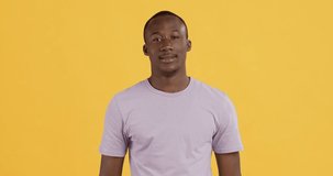 Unbelievable. Emotional happy african american guy screaming WOW, yellow studio background