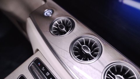 Rotating shot of a futuristic modern car dashboard with controls and ventilation with steam coming out of the air conditioning vents. Steam coming out of air conditioning vents in a car dashboard.