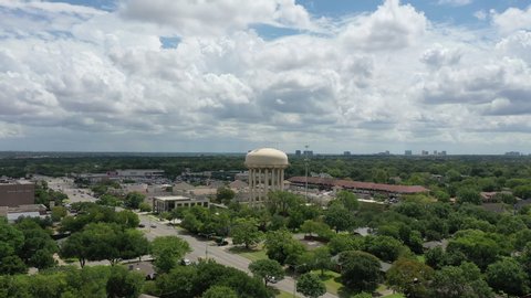 drone shot of a large white water tower in Dallas Texas, water and power, flying over a power plant in Texas, industrial plant with water tower. Ariel shot of water tower. 