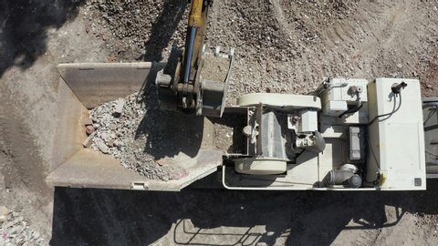 Smooth aerial view of demolition waste recycle machine on sunny day