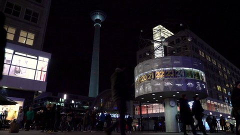 THE WORLD CLOCK, TRAM AND PEOPLE IN ALEXANDERPLATZ, BERLIN, GERMANY – 20 FEBRUARY 2019: Night time video of The World Clock, tram and people in Alexanderplatz with the TV Tower and Railway Station