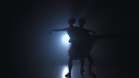 Silhouette of young man practicing in classical ballet pirouette with ballerina