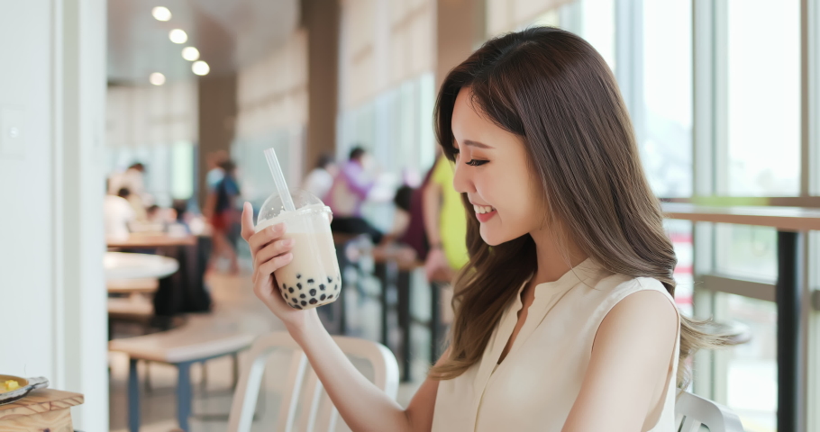 asian young woman look and drink bubble tea in the restaurant