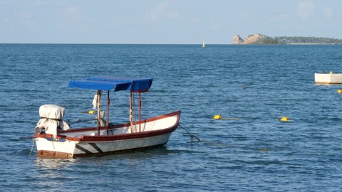 Fishing boats near coastline. Calm idyllic sea blue water surface