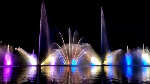 Night laser fountain show, on the Roshen embankment, the Ukrainian city of Vinnytsia. Musical fountain with laser animations. Musical fountain Roshen in Vinnytsia, Ukraine. Evening show Roshen fountain.