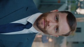 Vertical Video Portrait of Attractive Bearded Business Man Entrepreneur looking Serious at Camera Ambitious Male Leadership. Confident Boss Businessman on Background of the Business District.