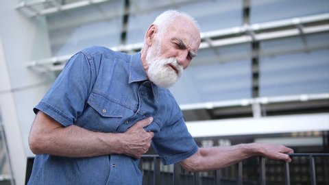 Senior sick pensioner feeling sharp chest pain outdoors, symptom of heart attack