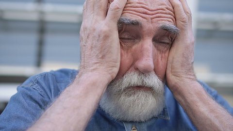 Sick aged man holding head, feeling ache and dizziness, symptom of stroke