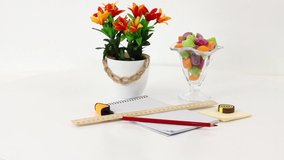 Colored office supplies and consumables on white spinning table background.