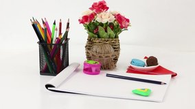 Colored office supplies and consumables on white spinning table background.