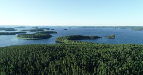 Aerial view of of islands on a blue lake Paijanne. Blue lake, islands and green forest from above on a sunny summer evening. Lake landscape in Finland
