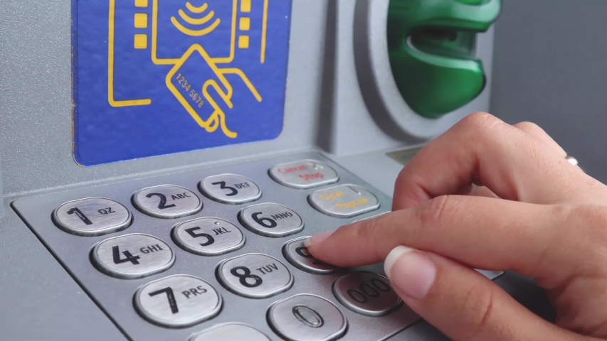 The girl drives the PIN code at the ATM. Royalty-Free Stock Footage #1058087143