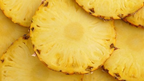 Sliced pieces of delicious pineapple fruit. Tropical rotating food