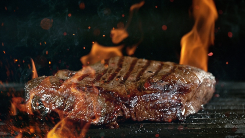 Close-up of falling tasty beef steak on iron cast grate, super slow motion, filmed on high speed cinematic camera at 1000 fps. Royalty-Free Stock Footage #1058103322