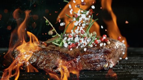 Close-up of falling tasty beef steak on iron cast grate, super slow motion, filmed on high speed cinematic camera at 1000 fps.