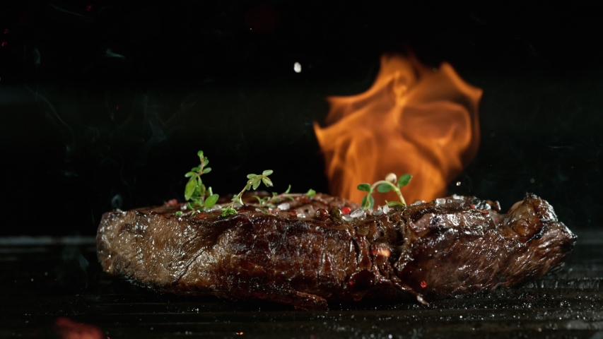 Close-up of falling tasty beef steak on iron cast grate, super slow motion, filmed on high speed cinematic camera at 1000 fps. Royalty-Free Stock Footage #1058103328