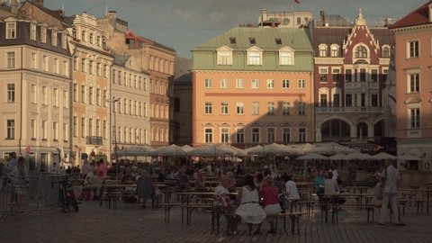 Riga, Latvia - 14 August 2020. The old town architecture beauty. Panoramic landscape of Dome square in summer calm sunny day with tourists and citizens resting in a street cafe in the capital center.