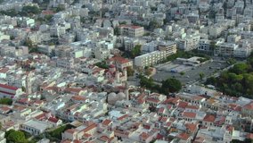 Aerial view of the city of Rethymno on the island of Crete in greece, in the frame of European houses, temples and sports grounds, evening time, aerial video