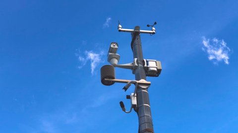 Automatic weather station, with a weather monitoring system and video cameras for observation. Against the background of blue sky clouds.