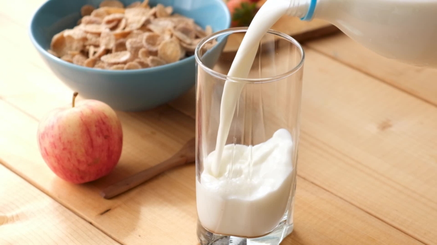 Slow motion Pouring milk in glass on wooden table. Healthy breakfast at the morning. Cereals and milk Royalty-Free Stock Footage #1058122864