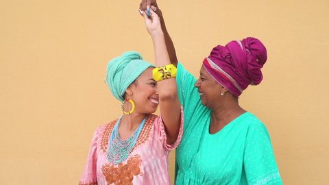 Happy mother and daughter with traditional african dancing together - Family lifestyle and ethnic concept - Slow Motion