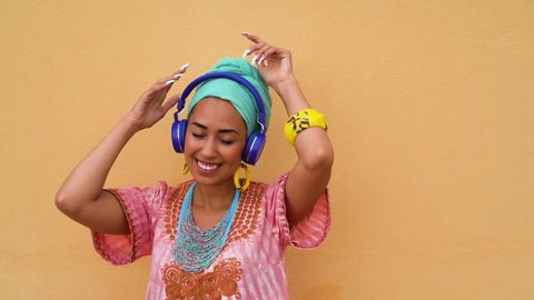 Young african woman listening music with headphones - Happy girl having fun dancing and singing - Lifestyle concept - Slow Motion