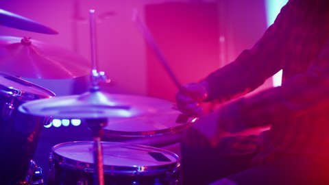 Rock Band Performing at a Concert in a Night Club. Close Up Portrait of a Drummer Playing the Drums. Live Music Party in Front of Bright Colorful Strobing Lights on Stage.