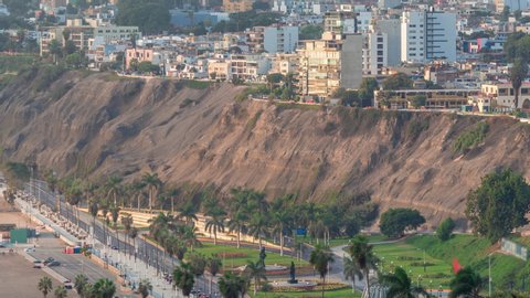Aerial view of Lima's shoreline including the districts of Barranco and Chorrillos timelapse. Early morning during sunrise with traffic on a street near park. Peru