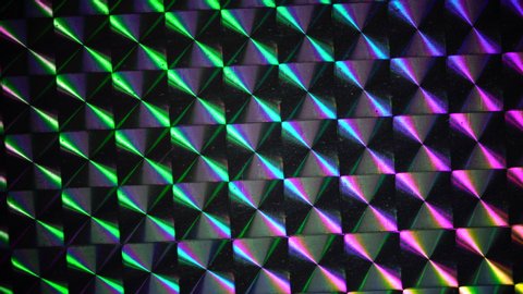 real shiny led light moving over silver rainbow holo foil, glitter pattern background loop, cool music video transition or video overlay. holographic surface in 4k.