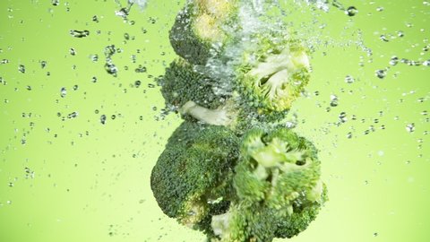 Super slow motion of broccoli pieces flying up in the air with water splashes. Filmed on high speed cinema camera, 1000 fps.