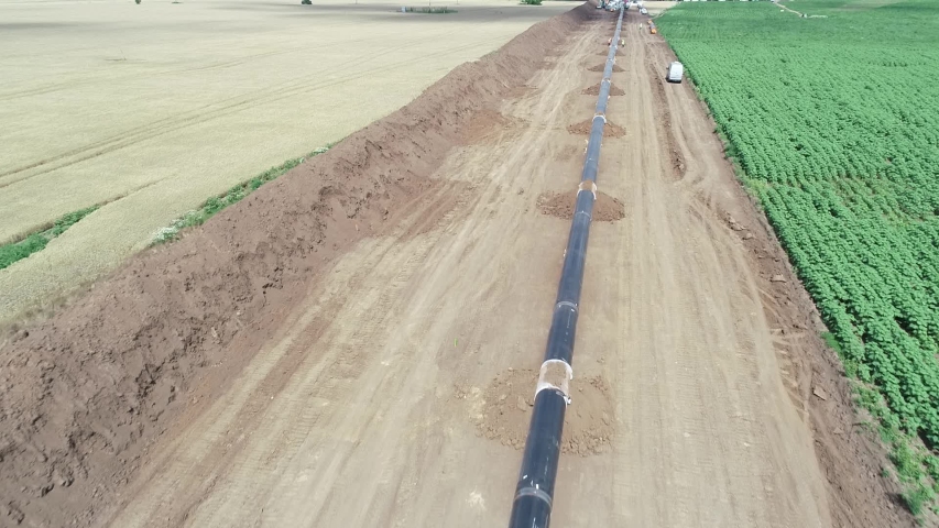 Aerial view of gas and oil pipeline construction. Pipes welded together. Big pipeline is under construction. Royalty-Free Stock Footage #1058131087