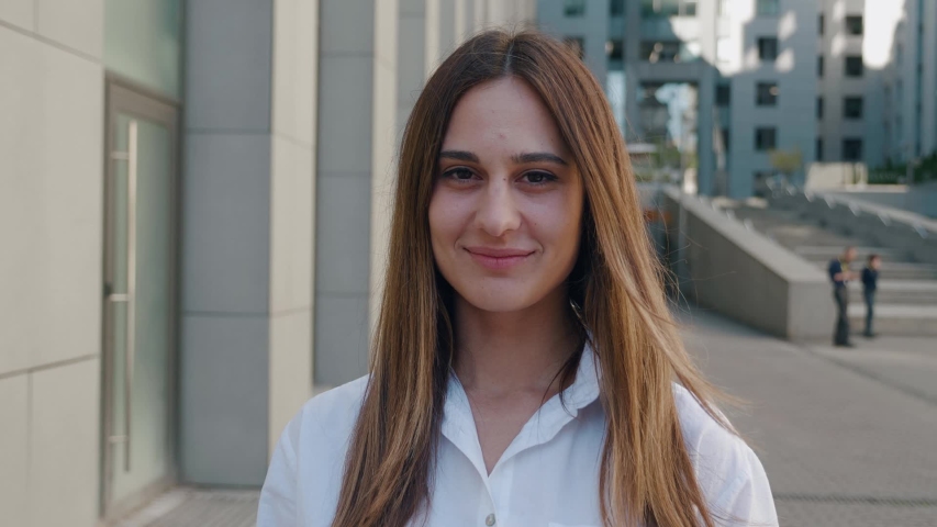 Close up portrait of an attractive light brown woman opening her dark- brown eyes and smiling shooting with steadicam on business center background 4k | Shutterstock HD Video #1058131999