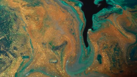 Tidewater Green, a deep blueish green shade, white and shiny gold colors oil paint pouring close up. Fluid Art painting. Moving flowing stream of liquid paint. Decorative abstract background