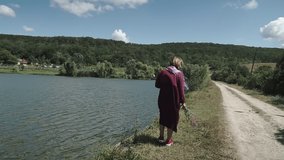 Women in long dress walks along the lake shore. A walk in the fresh air.