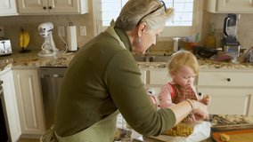 Loving and tender grandmother making cookies with granddaughter toddler - baby girl mostly just eating the cookie dough - Powered by Shutterstock - Get 15% off with code: PIKWIZARD15