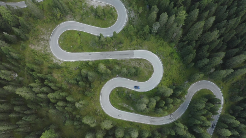 Town down aerial tracking view of sports car driving over winding German roads Royalty-Free Stock Footage #1058151826