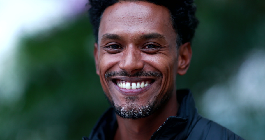 Portrait of mixed race man smiling to camera. Friendly happy african american descent person face outdoors Royalty-Free Stock Footage #1058153275