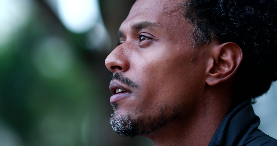 Contemplative man from african descent pondering. Pensive black mixed race man portrait staring Royalty-Free Stock Footage #1058153281