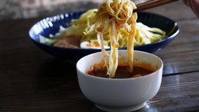 Hiroshima-style spicy tsukemen. Close-up video of soaking noodles in soup.