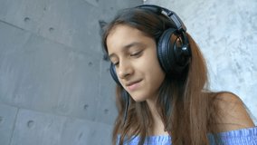 girl with headphones online learning to play the piano on a laptop.