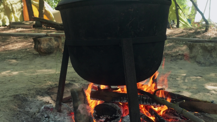 Close up view of balck pot on fire. Lunch for tourists after hiking.
