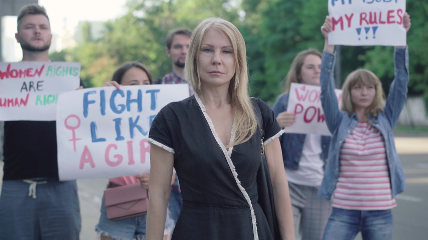 Confident Caucasian woman crossing hands in no gesture on demonstration against sexism and women rights violation. Portrait of beautiful Caucasian female activist protesting against gender inequality. | Shutterstock HD Video #1058172970