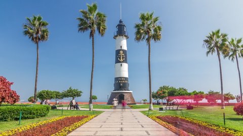 Lighthouse monument in the Park of Love of Miraflores timelapse hyperlapse. Green lawn with flowers and palms. Coastline park in nice sunny day. Lima, Peru