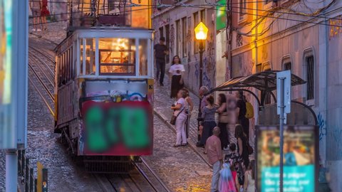 Lisbon's Gloria funicular day to night transition timelapse located on the west side of the Avenida da Liberdade connects downtown with Bairro Alto. It's classified as a national monument opened 1885